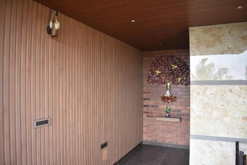 a room with a brick wall with a tree on it at SScoconest Luxury Service Apartments in Chikmagalūr