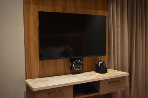 a flat screen tv on a wall in a hotel room at SScoconest Luxury Service Apartments in Chikmagalūr