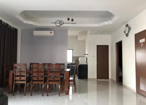 een eetkamer en een keuken met een tafel en stoelen bij 30 corner villa house in Pangkor