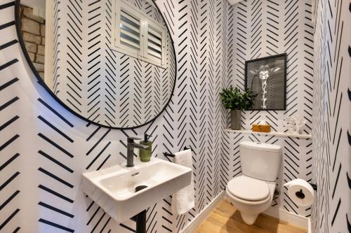 uma casa de banho com um lavatório, um espelho e um WC. em Bright Simbithi apartment with beautiful sea views em Ballito