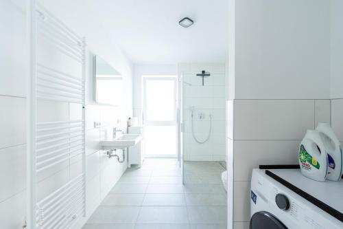 a white bathroom with a sink and a toilet at Lit Living: Luxus - Box Spring - Parking - Terrace in Ludwigshafen am Rhein