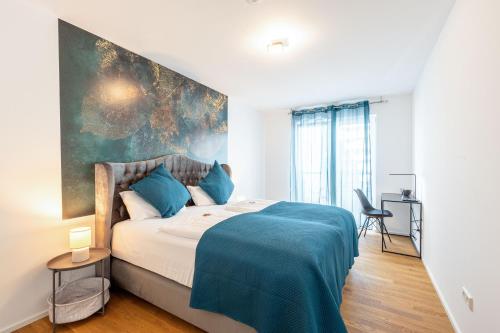 a bedroom with a large bed with a blue blanket at Lit Living: Luxus - Box Spring - Parking - Terrace in Ludwigshafen am Rhein