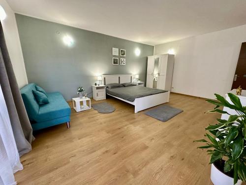 ein Schlafzimmer mit einem Bett und einem blauen Stuhl in der Unterkunft Apartament Novara 1 in Craiova