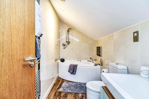 a bathroom with a tub and a toilet and a sink at Executive Lakeside 4 Bed Townhouse in Simpson