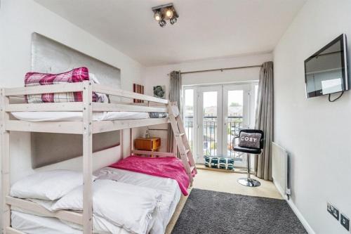 a bedroom with two bunk beds and a tv at Executive Lakeside 4 Bed Townhouse in Simpson