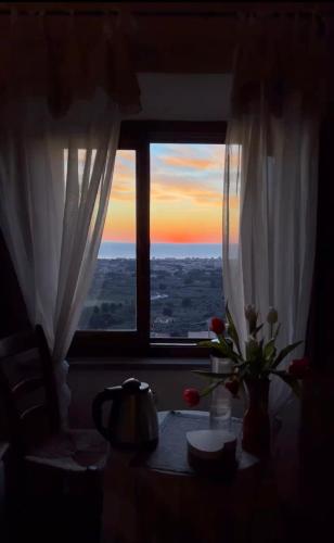 a window with a vase of flowers on a table at Locanda Il Sigillo B&B e Ristorante in Rosignano Marittimo