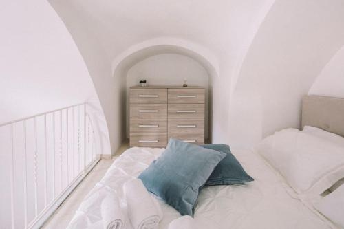 a white bedroom with a bed and a dresser at Casa del lazzaro in Maiori