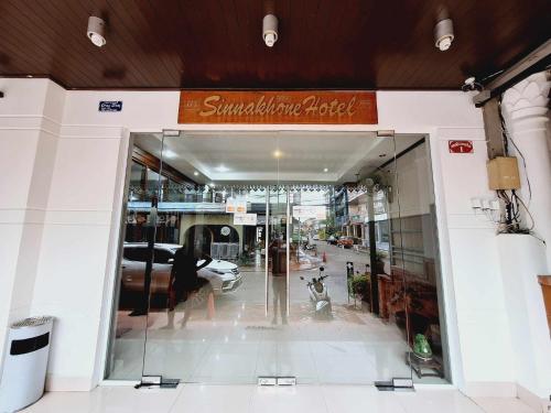 a woman walking into a building with a dog in the doorway at Sinakhone Vientiane Hotel in Vientiane