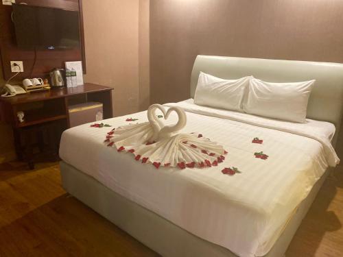 a white bed with a swan decoration on it at Sinakhone Vientiane Hotel in Vientiane