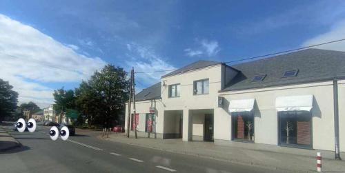 a white building with three eyes on the side of the street at Noclegi w Dawnej Łaźni in Żarki