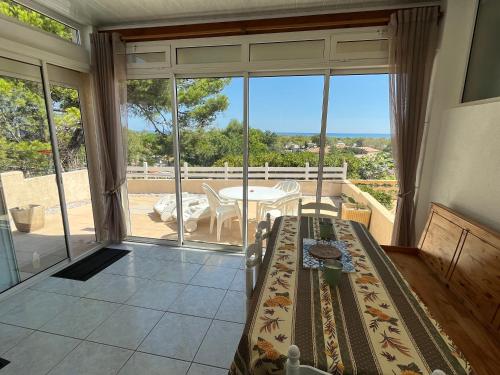 a room with a view of a balcony with a table at Panorama Mer in Saint Pierre La Mer