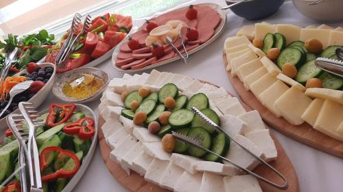 a table topped with different types of cheese and vegetables at Hotel Labella Bergama in Bergama
