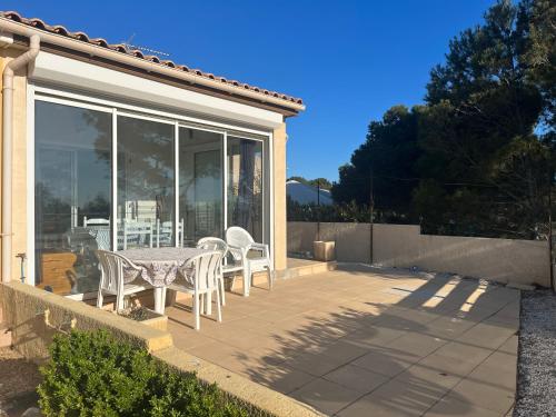a patio with a table and chairs on it at Panorama Mer in Saint Pierre La Mer