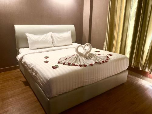 a bedroom with a bed with a heart decoration on it at Sinakhone Vientiane Hotel in Vientiane
