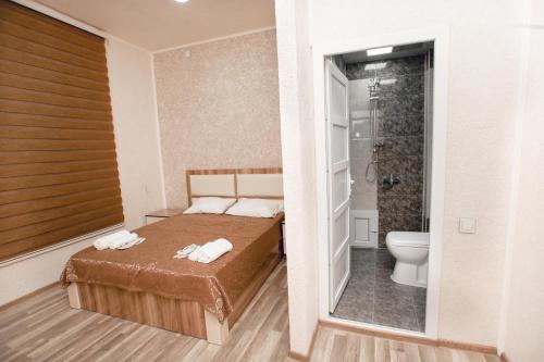 a bedroom with a bed and a shower and a toilet at NM Butik Hotel in Ganja