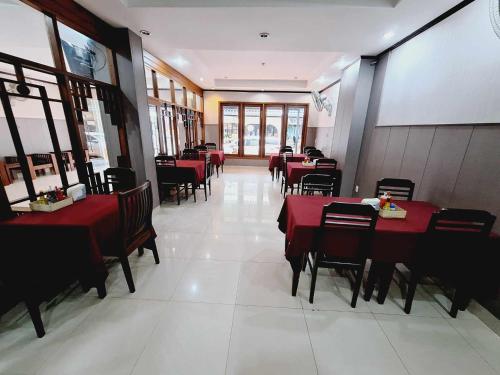 ein Esszimmer mit roten Tischen und Stühlen in einem Restaurant in der Unterkunft Sinakhone Vientiane Hotel in Vientiane