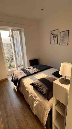 une chambre avec un grand lit et une fenêtre dans l'établissement Magnifique T2 Lumineux 3 étoiles - Centre Aix les Bains, à Aix-les-Bains