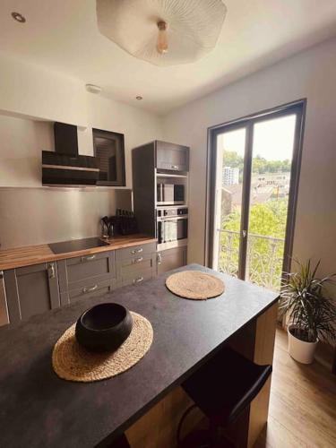 une cuisine avec une table avec deux chapeaux dans l'établissement Magnifique T2 Lumineux 3 étoiles - Centre Aix les Bains, à Aix-les-Bains