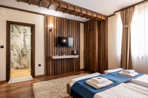 a bedroom with a bed with towels on it at Beluga Guest House in Velingrad