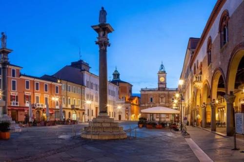 a city square with a clock tower in the background at Cairoli Apartment in Ravenna