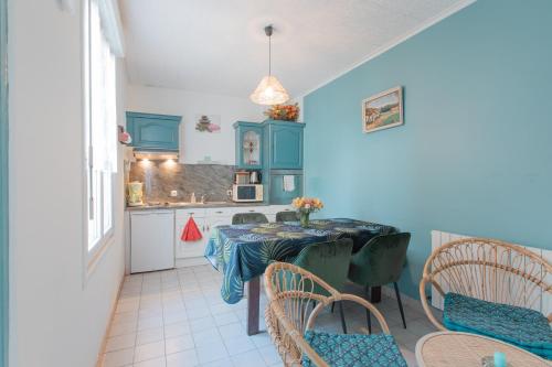 eine Küche mit einem Tisch und Stühlen im Zimmer in der Unterkunft Gîte de la Plage in Lézardrieux