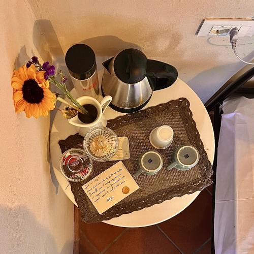 a table with a tray with a tea pot and flowers at Locanda Il Sigillo B&B e Ristorante in Rosignano Marittimo