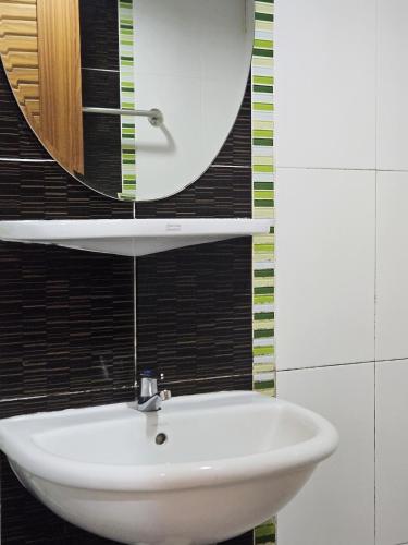 a white sink in a bathroom with a mirror at Pacific Residence in Hat Yai