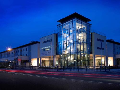 a large glass building at night with a street at Shearwater Hotel & Spa in Ballinasloe