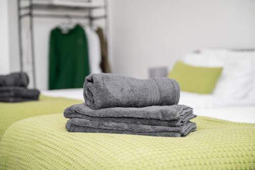 a pile of towels sitting on top of a bed at Spacious Home In The Heart of West Yorkshire in Brighouse