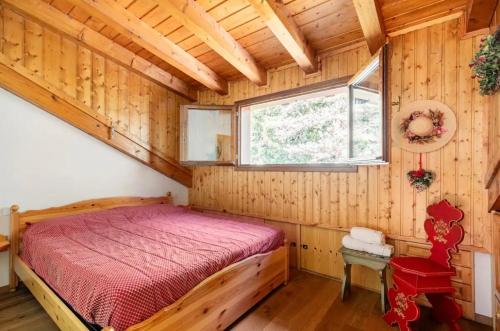 sypialnia z łóżkiem w drewnianym domku w obiekcie Chalet Pian della Velma w mieście Giralba