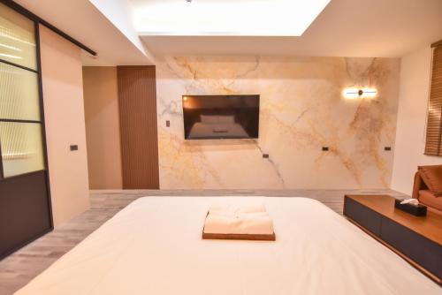 a bedroom with a bed and a tv on a wall at Two Couples Leisure Art Motel in Tainan