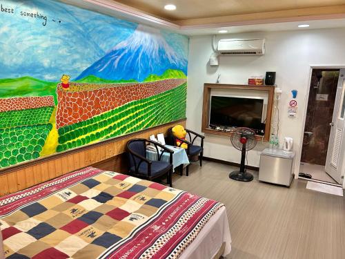 a room with a bed and a painting on the wall at TREE HOUSE in Pingtung County