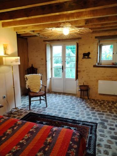 une chambre avec un lit, une chaise et une fenêtre dans l'établissement La Chabossière, à Montbizot