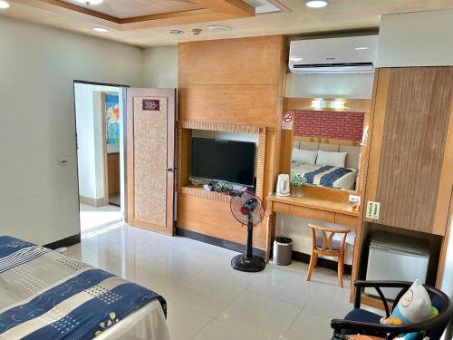 a bedroom with a bed and a desk and a television at TREE HOUSE in Pingtung County