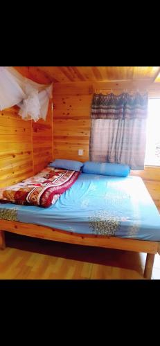 uma cama num quarto com uma parede de madeira em Family homestay mrhieu em Lao Cai