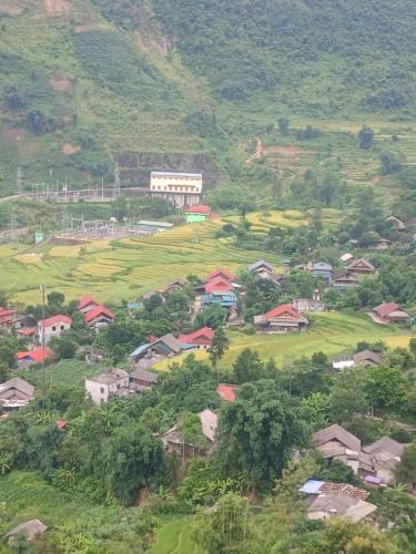 uma pequena aldeia numa colina com casas e árvores em Family homestay mrhieu em Lao Cai