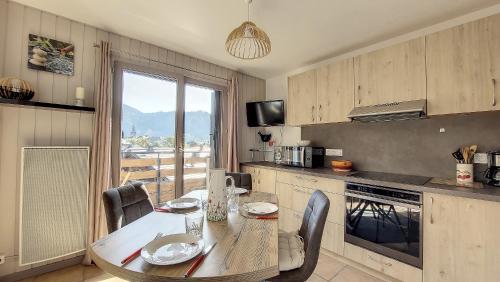 une cuisine avec une table et des chaises et une fenêtre dans l'établissement Oree de Morzine 32B, à Montriond