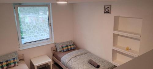 ein kleines Zimmer mit einer Bank und einem Fenster in der Unterkunft Messewohnung in Hannover