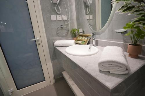 Un baño con lavabo, espejo y ducha. en Ajmkan Resort, en Al Khobar