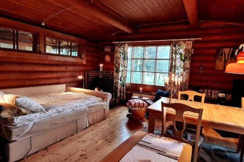 a bedroom with a bed and a table in a room at Cozy Beach Cabin - close to city center in Pargas