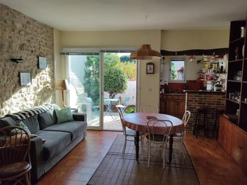 een woonkamer met een bank en een tafel bij La cour du Moulin/T3/centre-ville/wi-fi/Terrasse in La Rochelle