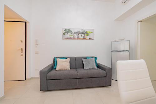un soggiorno con divano e frigorifero di La casa di Alessia nel centro di Como - Alessiatravelling a Como