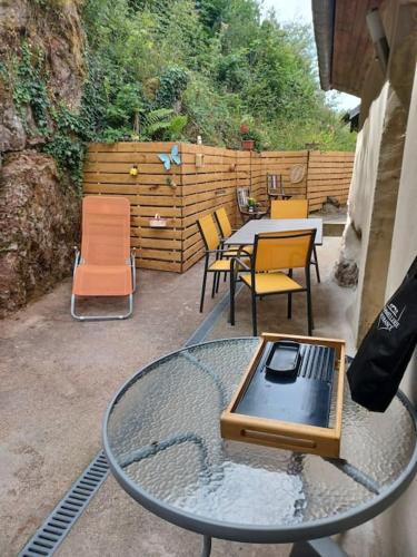a patio with a table and chairs and a table and chairs at Logement dans un cadre apaisant à Moussey dans les Vosges in Moussey