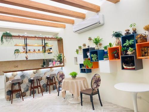 une chambre avec une table, des chaises et des plantes sur le mur dans l'établissement Seed House, à Taïtung