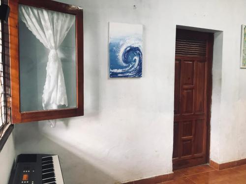a wall with a mirror and a picture and a piano at RosiesHome in Da Lat