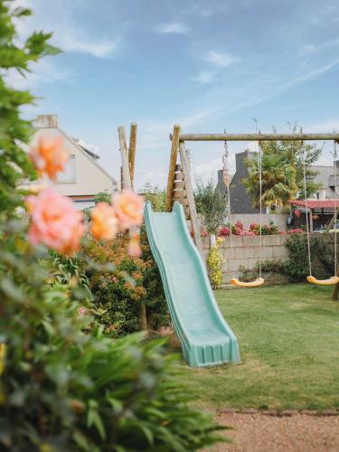 a green slide in a yard with flowers at Gîte des Gardiens de Phare in Lézardrieux