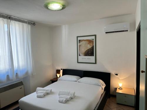 1 dormitorio con 1 cama con toallas en Casa Carlotta en Follonica