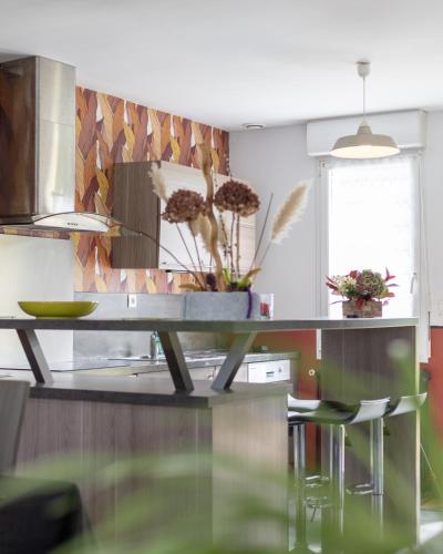 a kitchen with a counter with a table and chairs at Gîte des Gardiens de Phare in Lézardrieux