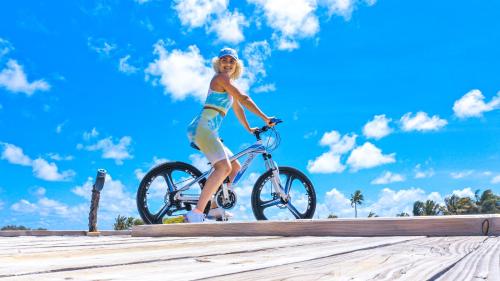 Ein junges Mädchen, das am Strand Fahrrad fährt. in der Unterkunft South Palm Resort Maldives with First-ever floating Spa in Midu
