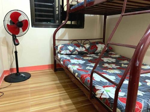 1 Schlafzimmer mit 2 Etagenbetten und einem Ventilator in der Unterkunft Eve's Place Transient Apartment in Tanay